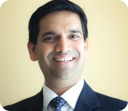 A smiling man wearing a suit and tie